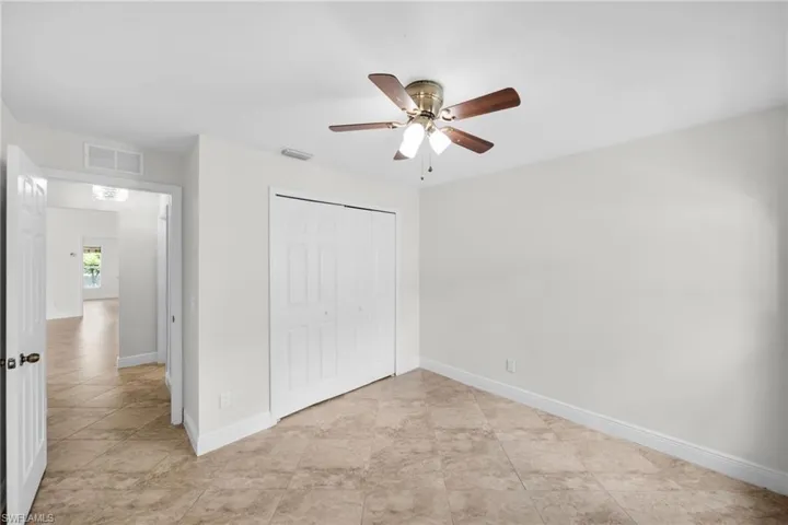 Unfurnished bedroom featuring a closet, a \ ceiling fan, and light tile patterned floors