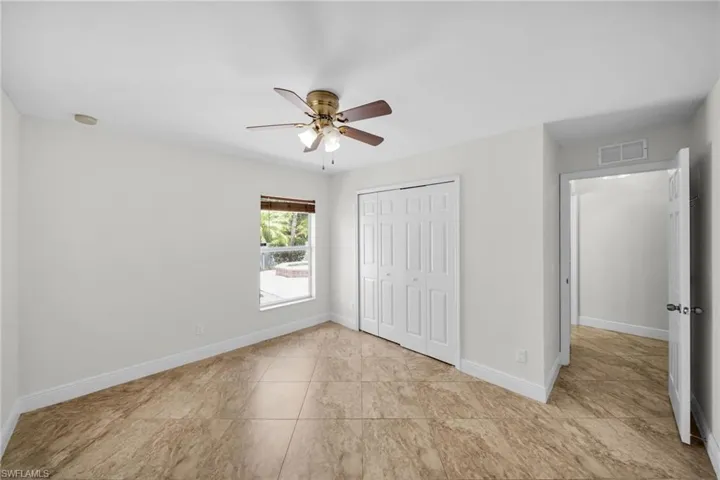 Unfurnished bedroom / with a closet, ceiling fan, and tile patterned flooring