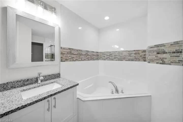 Bathroom with vanity and a bath