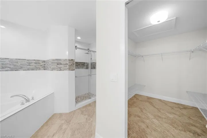 Spacious closet with light tile patterned floors