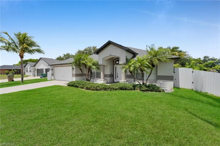 Single story home featuring stucco siding, concrete driveway, an attached garage, and a gate