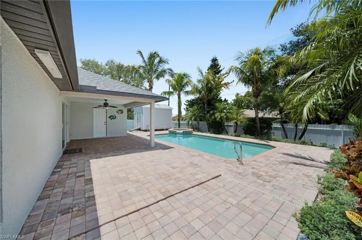 View of pool with a ceiling fan, a patio area, a fenced backyard, and a pool with connected hot tub