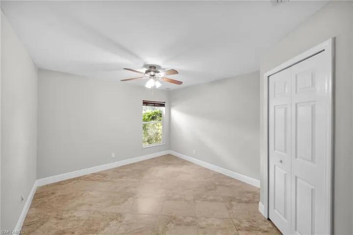Spare room featuring a ceiling fan and baseboards
