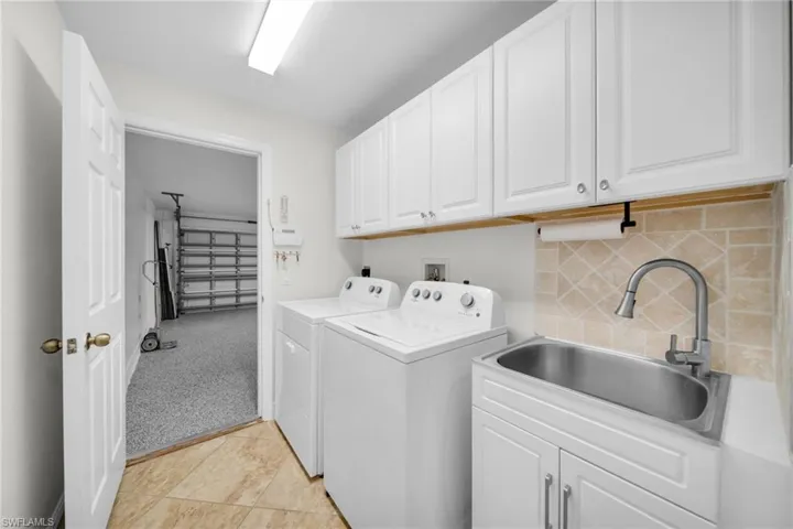 Laund'ry area featuring cabinet space and separate washer and dryer