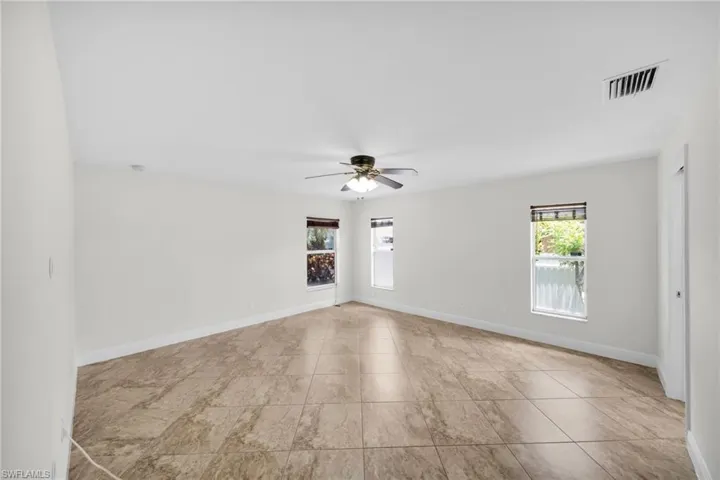 Tiled spare room with a cAeiling fan anvd baseboards