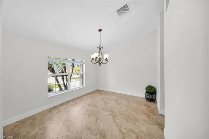 Empty room with a chandelier and l baseboards