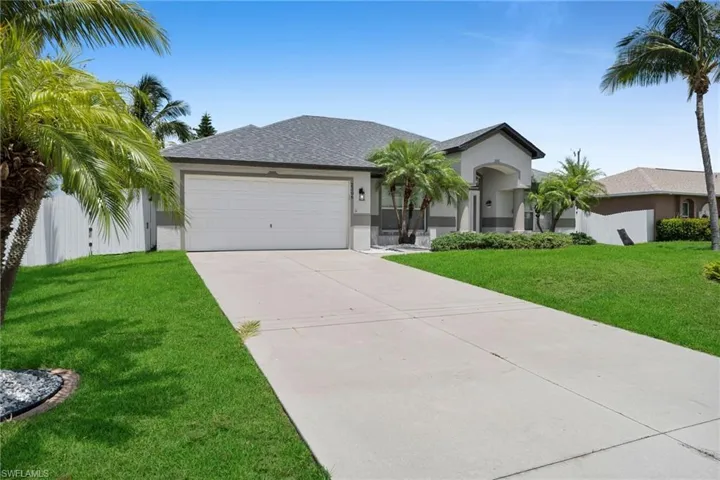 Ranch-style home featuring an attached garage, stucco siding, concrete driveway, and a front lawn