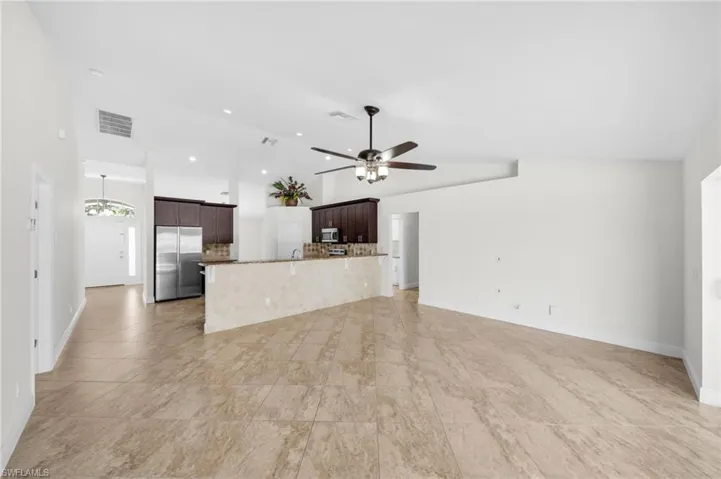 Unfurnished living room featuring a ceiling fan, high vaulted ceiling, and recessed lighting
