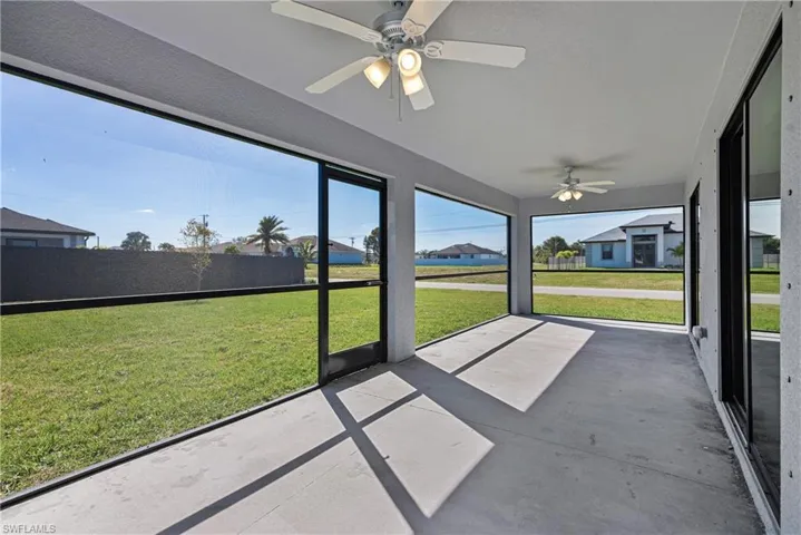 Unfurnished sunroom with ceiling fan and a residential view