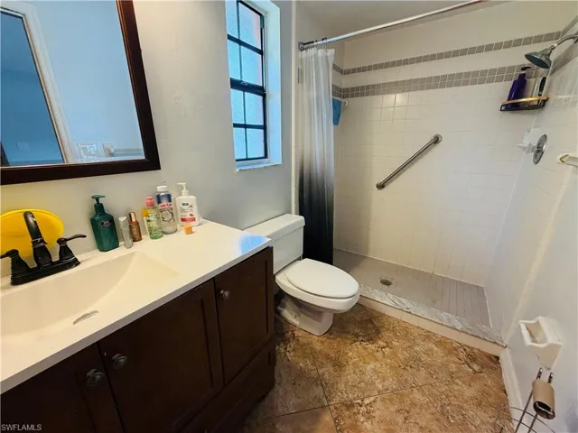Walk-in shower with tiled walls and grab bar