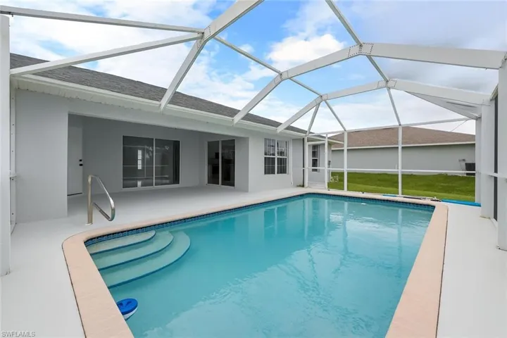 Swimming pool with a sunroom, a lanai, and a patio