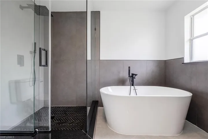 Bathroom with a stall shower, a freestanding tub