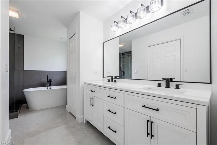 Full bathroom featuring double vanity, a freestanding tub and shower.