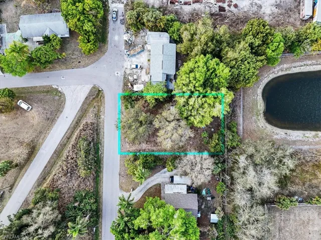 Aerial view of property and surrounding area with property parcel outlined and a nearby body of water