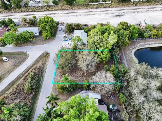 Aerial view of property and surrounding area with property parcel outlined and a nearby body of water