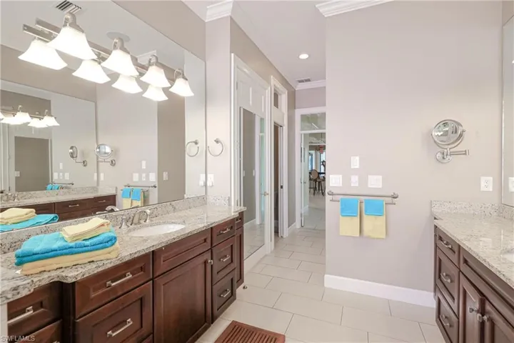 Bathroom with tile patterned floors, crown molding, and vanity