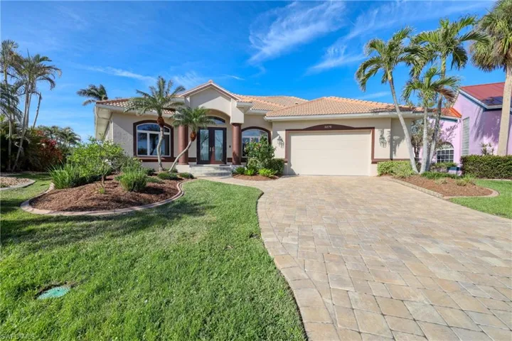 Mediterranean / spanish-style home with french doors, a front lawn, and a garage