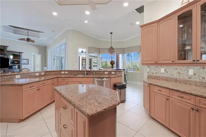 Kitchen with stainless steel dishwasher, ceiling fan, sink, pendant lighting, and a center island