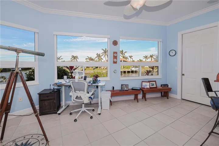Office area with ceiling fan, light tile patterned flooring, and crown molding