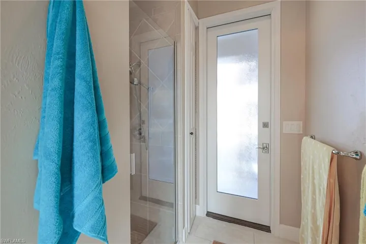 Bathroom with tile patterned floors and a shower with shower door