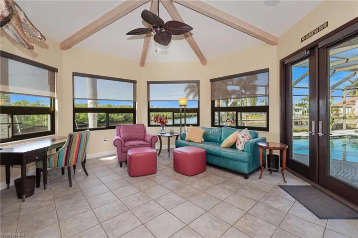 Sunroom with french doors, lofted ceiling with beams, and ceiling fan