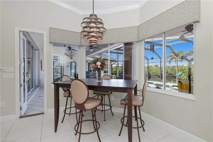 Tiled dining room featuring ornamental molding