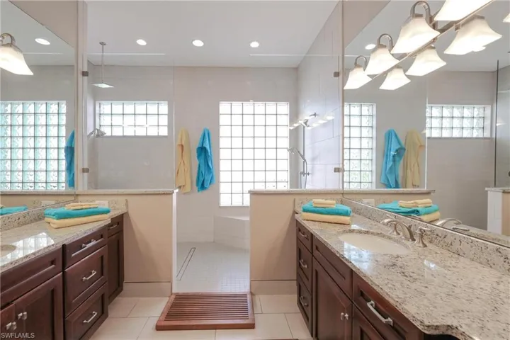 Bathroom with tile patterned floors, vanity, and tiled shower