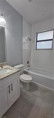 Full bathroom featuring vanity, shower / bath combination, and light tile patterned floors