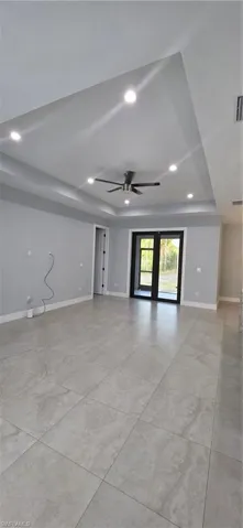 Spare room with recessed lighting, a ceiling fan, and a raised ceiling