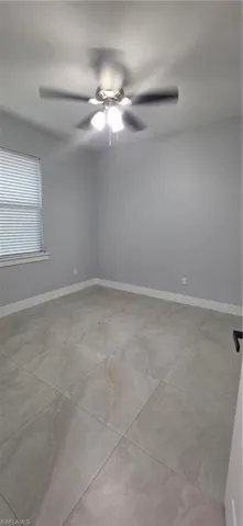 Unfurnished room with baseboards and ceiling fan