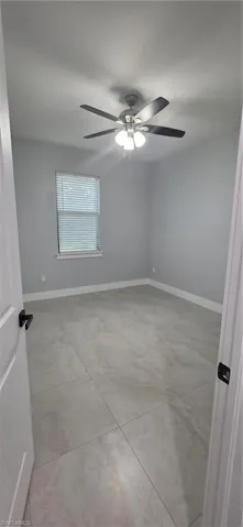 Empty room with baseboards and ceiling fan