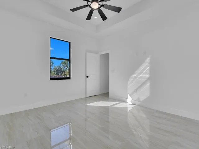 Spare room with a raised ceiling and ceiling fan