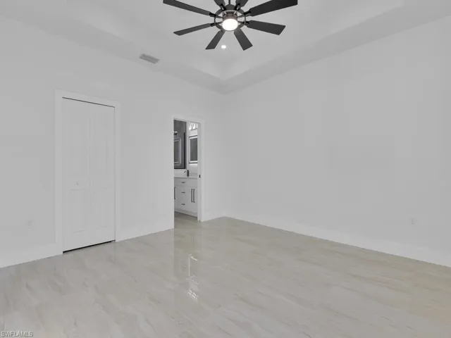 Spare room with ceiling fan and a tray ceiling