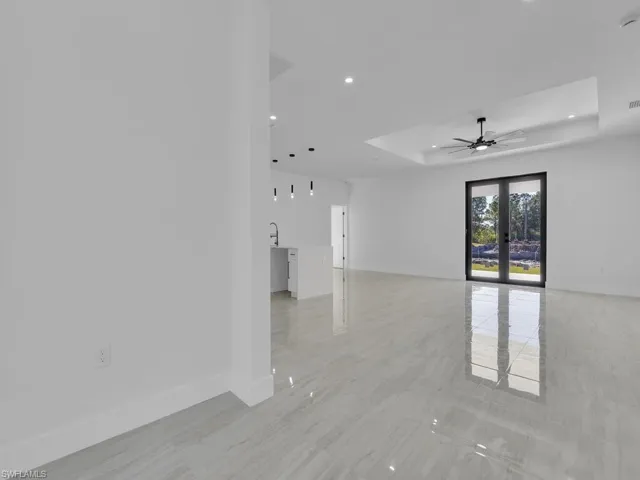 Spare room featuring french doors, ceiling fan, a tray ceiling, and sink