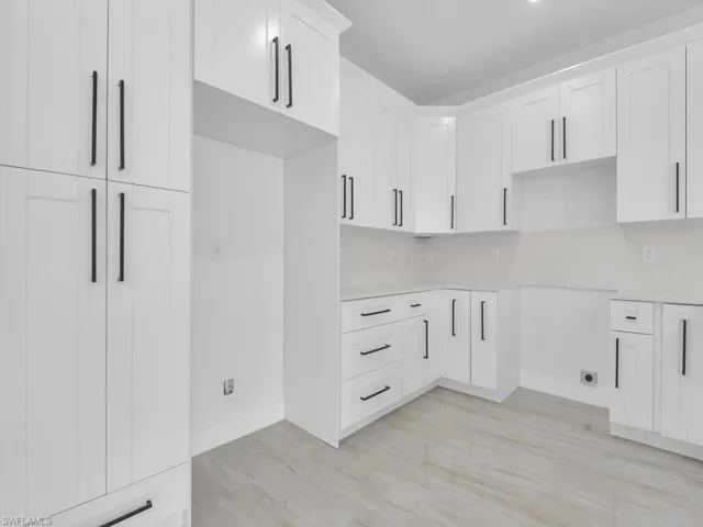 Kitchen with white cabinetry and backsplash