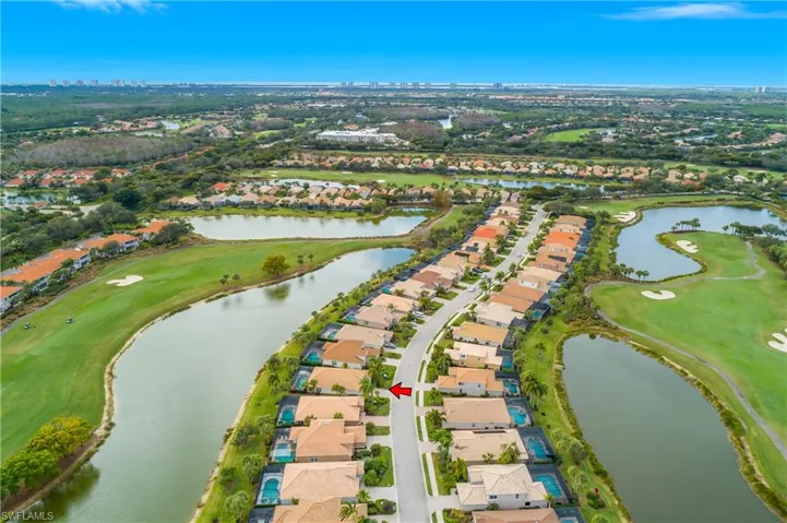 Aerial view of property and surrounding area featuring a golf club and nearby suburban area