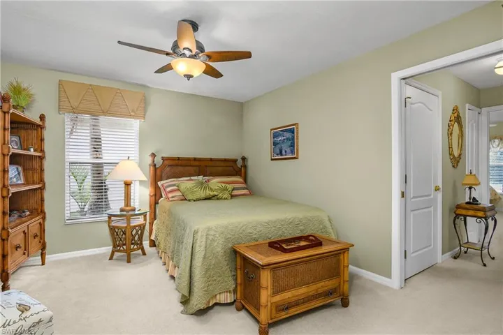 Bedroom with light colored carpet and ceiling fan