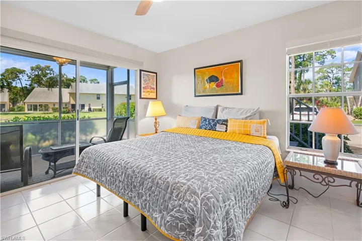 Tiled bedroom with multiple windows and ceiling fan