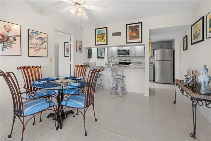 Dining room with ceiling fan, sink, and light tile patterned floors