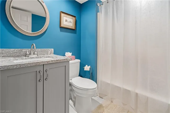 Full bathroom featuring tile patterned flooring, vanity, toilet, and shower / bathtub combination with curtain