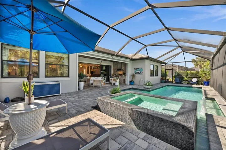 View of swimming pool featuring a lanai, ceiling fan, a patio area, and an in ground hot tub