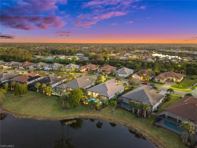 Aerial view at dusk featuring a water view