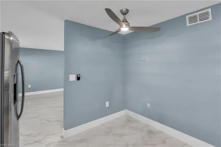 Unfurnished room with light marble finish flooring and a ceiling fan