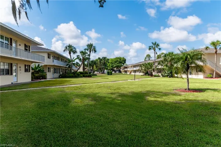 View of property's community featuring a yard and a balcony