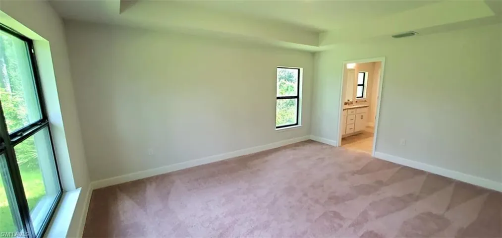 Primary bedroom with ensuite bath and carpet