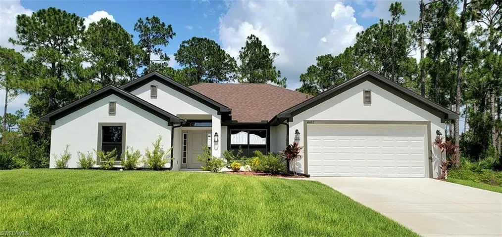 Ranch-style house with a garage and a front lawn