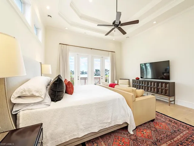 Bedroom with wood finished floors, access to exterior, a tray ceiling, crown molding, and recessed lighting