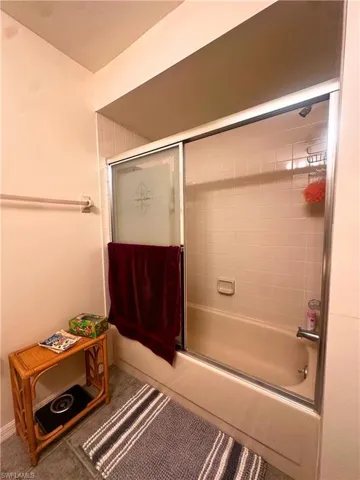 Full bath with bath / shower combo with glass door and tile patterned floors