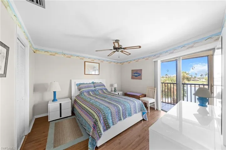 Bedroom with wood finished floors, access to exterior, and a ceiling fan