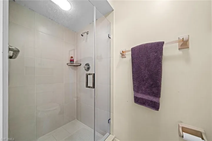 Full bathroom featuring a shower stall and a textured ceiling